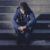 Troubled youth sits on stairs